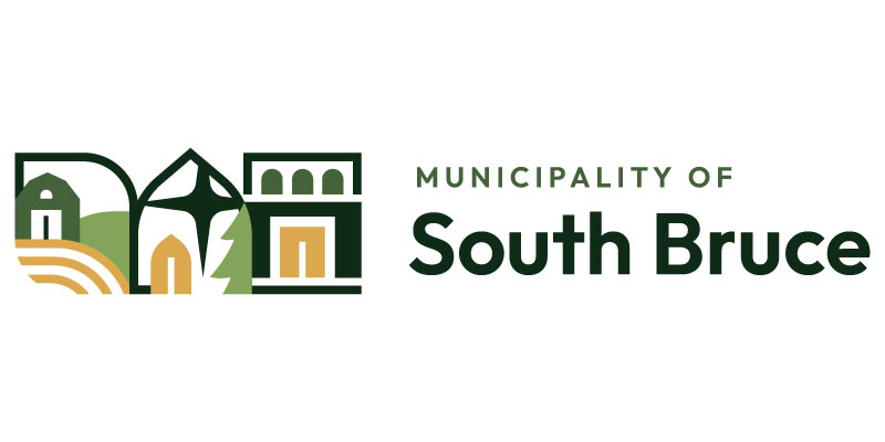 An oval logo with the words Municipality of South Bruce. The background is a blue sky, green hills and blue water with a few sprigs of wheat.